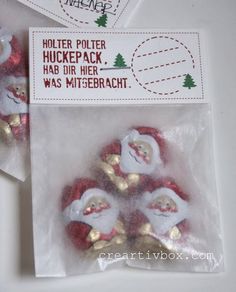 three plastic santa clause buttons in a bag