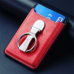 a red leather case with a metal ring on the front and back side of it