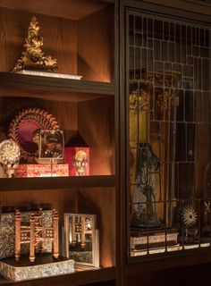 the shelves are filled with decorative items and glass doors on top of each shelf is an ornate clock