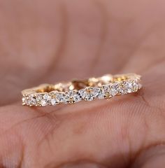 a close up of a person's hand holding a wedding ring