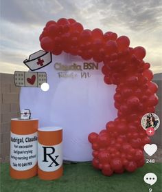 the balloon arch is decorated with red balloons and an orange canister next to it