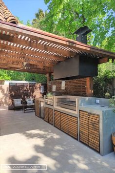 an outdoor kitchen with grill and seating area