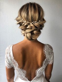 the back of a woman's head with braids and pearls in her hair