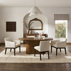 a dining room table with chairs around it and a mirror on the wall behind it