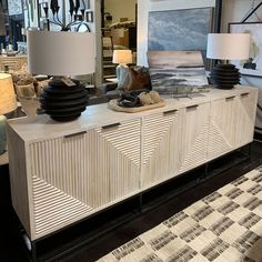 a large white cabinet sitting on top of a floor next to lamps and rugs