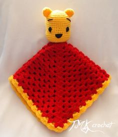 a crocheted winnie the pooh blanket is laying on a white bed sheet