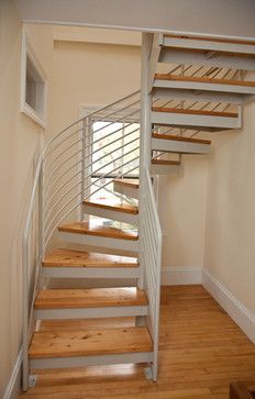 a spiral staircase in an empty room with wood floors