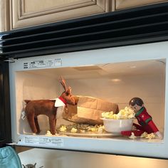 a microwave with stuffed animals in it and popcorn on the inside, including a reindeer