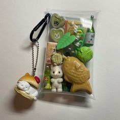 a keychain with various items in it on a white surface, including an animal and other things