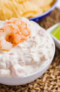 a bowl of shrimp dip with chips on the side