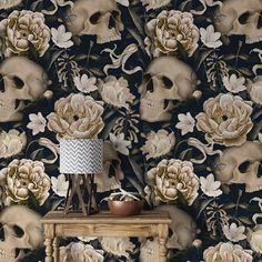 a wallpaper with skulls and flowers on the side table next to a vase full of flowers