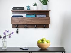 a bowl of green apples sitting on top of a wooden table next to a phone