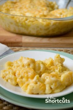 a white plate topped with macaroni and cheese next to a casserole dish