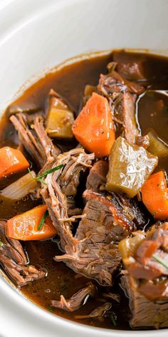 a white bowl filled with beef and carrots