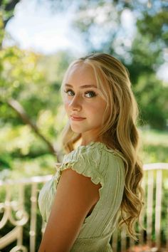 a beautiful young blond woman sitting on top of a bench