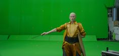 a man standing in front of a green screen with his arms out to the side