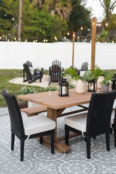 an outdoor dining table with chairs and lights