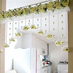 the kitchen is decorated with white roses and beaded curtains, hanging from the ceiling