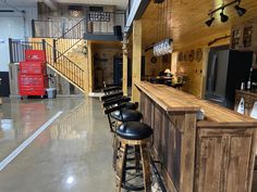 the bar is lined up with chairs and barstools for people to sit at