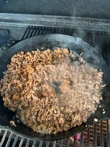 the food is cooking on the grill in the outdoor area with it's lid open