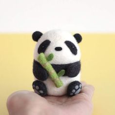 a small stuffed panda bear holding a bamboo stick