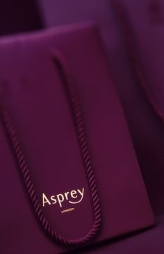 a purple shopping bag with the word asprey on it's front pocket