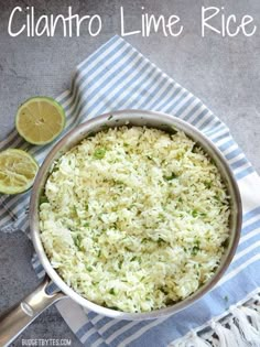 a pan filled with rice and limes on top of a blue and white towel