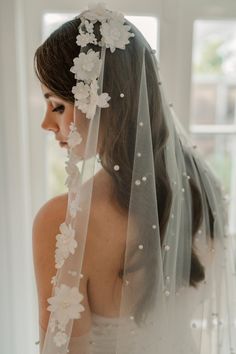 a woman wearing a veil with flowers on it