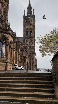 an old building with stairs leading up to it and a clock tower in the background