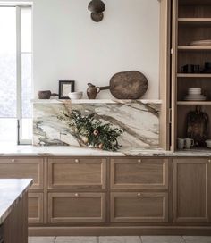 a kitchen with marble counter tops and wooden cabinets