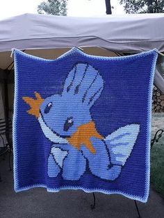 a blue crocheted blanket with an image of a fish holding a starfish