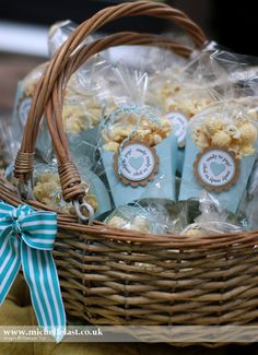 a basket filled with popcorn and wrapped in cellophane wrap, tied with a blue ribbon