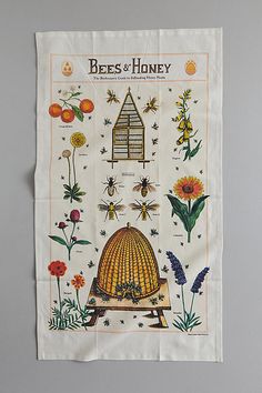 the bees and honey tea towel is hanging on a white wall, with an image of a beehive