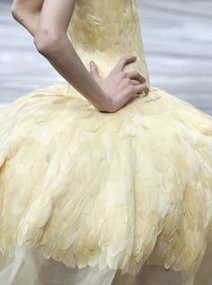 a woman in a yellow dress with her hands on her hips