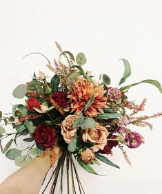 a woman holding a bouquet of flowers in her hand