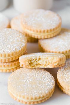 several cookies are stacked on top of each other with powdered sugar in the middle