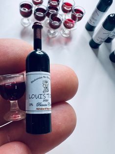 a hand holding a miniature bottle of wine