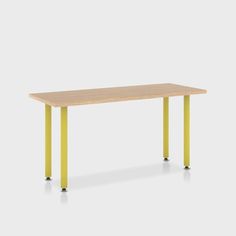 a rectangular table with yellow legs and a wooden top, against a white background or wall