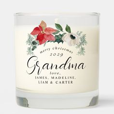 a glass candle with the words grandma and poinsettis on it, in front of a white background