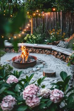 an outdoor fire pit surrounded by flowers and lights