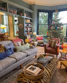 a living room filled with lots of furniture and a christmas tree in the window sill