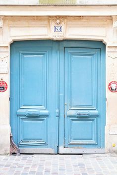 two blue doors are open in front of a building