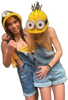 two girls in overalls are posing for the camera with a minion on their head