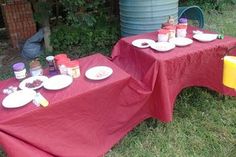 two red tables with plates and cups on them