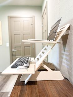 a laptop computer sitting on top of a white stand