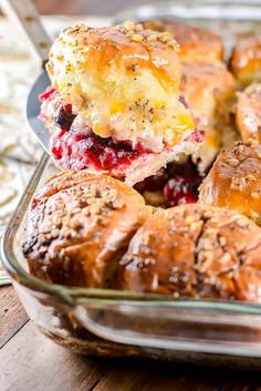 a casserole dish filled with rolls covered in cheese and cranberry sauce