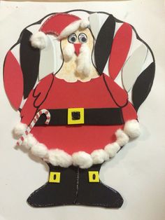 a paper cut out of santa clause holding a candy cane