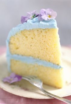 a piece of cake with blue frosting and purple flowers