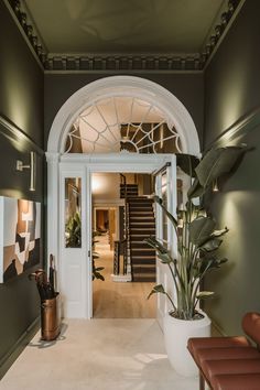 the entrance to a house with an arched doorway and staircase leading up to it's second floor