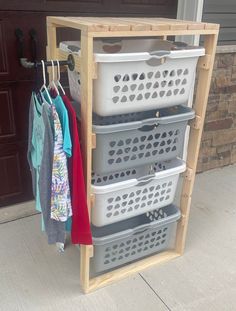 a wooden rack with baskets and clothes hanging from it's sides on the side of a garage door